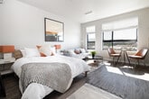 This thoughtfully designed studio in Boise, Idaho offers a smart, open-concept layout that maximizes every square foot. Light-toned luxury vinyl plank flooring runs throughout, unifying the space and lending a clean, modern aesthetic. Natural light pours in through a large window at the far end of the unit, illuminating the combined living and sleeping area, which comfortably accommodates a full bedroom setup alongside a living space. A wall-mounted mini-split HVAC unit ensures year-round climate comfort.

The galley-style kitchen is well-appointed with white flat-panel cabinetry, quartz countertops, a white subway tile backsplash, and open wood shelving for additional storage. Stainless steel appliances — including a refrigerator, electric range, dishwasher, and microwave — provide full functionality. The double-basin stainless steel sink with a brushed nickel faucet adds a refined touch.

The bathroom features wood-look tile flooring, neutral grey walls, and clean, minimalist finishes. A dedicated closet offers practical storage solutions. The entry corridor flows seamlessly into the kitchen and living areas, creating an efficient and cohesive floor plan. This studio is an ideal option for those seeking a modern, well-equipped living space in the heart of Boise.