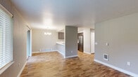 This single-floor residence offers a thoughtfully designed open-concept layout that seamlessly connects the living, dining, and kitchen areas. The living and dining space is finished with warm wood-look laminate flooring, neutral-toned walls, and a textured ceiling. A sliding glass door and multiple windows allow natural light to pour in, while a classic chandelier adds a decorative touch to the dining area. A baseboard heater runs along the exterior wall, ensuring comfort throughout the seasons.

The kitchen is efficiently arranged in a U-shaped configuration, featuring dark wood cabinetry, white countertops, and a full suite of stainless steel appliances including a refrigerator, electric range, and dishwasher. A peninsula with a built-in sink and breakfast bar connects the kitchen to the dining area, making it ideal for both everyday use and entertaining.

The bedrooms offer plush carpeting, neutral walls, and windows that bring in natural light and outdoor views. One bedroom includes a built-in closet with shelving and a hanging rod, providing practical storage. A separate carpeted room offers additional flexible living space. Throughout the unit, floor vents and wall-mounted heating units ensure year-round climate control, and clean white trim provides a crisp, finished look.