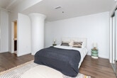 Located at 3550 W 6th St in the heart of Los Angeles, this single-floor unit offers a well-designed layout that balances open communal spaces with private retreats. The living and dining area forms the heart of the home, characterized by white-painted exposed beam ceilings that lend an airy, loft-like quality to the space. Large windows invite abundant natural light, creating a warm and inviting atmosphere complemented by rich hardwood flooring that runs throughout. The living area provides ample room for relaxed seating, while the adjacent dining space comfortably accommodates a round table, making it ideal for everyday meals or casual entertaining. The kitchen is outfitted with sleek white cabinetry, a clean white countertop, and a full suite of stainless steel appliances, including a refrigerator, range, dishwasher, and microwave. An in-unit washer is also conveniently integrated into the kitchen layout. The bedroom is a calm, neutral retreat featuring crisp white walls and a mirrored sliding-door closet with built-in shelving, offering generous storage. The overall design aesthetic is clean and modern, with a cohesive palette of whites and warm wood tones that creates a bright, livable environment throughout.