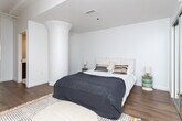Located at 3550 W 6th St in the heart of Los Angeles, this single-floor unit offers a well-designed layout that balances open communal spaces with private retreats. The living and dining area forms the heart of the home, characterized by white-painted exposed beam ceilings that lend an airy, loft-like quality to the space. Large windows invite abundant natural light, creating a warm and inviting atmosphere complemented by rich hardwood flooring that runs throughout. The living area provides ample room for relaxed seating, while the adjacent dining space comfortably accommodates a round table, making it ideal for everyday meals or casual entertaining. The kitchen is outfitted with sleek white cabinetry, a clean white countertop, and a full suite of stainless steel appliances, including a refrigerator, range, dishwasher, and microwave. An in-unit washer is also conveniently integrated into the kitchen layout. The bedroom is a calm, neutral retreat featuring crisp white walls and a mirrored sliding-door closet with built-in shelving, offering generous storage. The overall design aesthetic is clean and modern, with a cohesive palette of whites and warm wood tones that creates a bright, livable environment throughout.