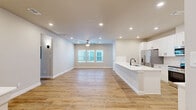 Located in Conroe, TX, this single-floor, 2-bedroom, 2-bathroom home offers a thoughtfully designed open-concept layout with modern finishes throughout. The combined kitchen and living area forms the heart of the home, featuring warm wood-look luxury vinyl plank flooring, recessed lighting, and a ceiling fan. The kitchen is outfitted with crisp white shaker cabinets accented by matte black hardware, quartz countertops, a subway tile backsplash, and stainless steel appliances, including a French door refrigerator and electric range. A large island with an undermount sink adds both functionality and style.

The generously sized primary bedroom is carpeted for comfort and includes a ceiling fan, direct access to the patio, and a walk-in closet with built-in shelving. The second bedroom also features carpet, vaulted ceilings, dual windows for natural light, and a ceiling fan. Both bathrooms maintain a clean, contemporary aesthetic with wood-look tile flooring and matte black fixtures, with one bathroom offering a full tub-shower combination.

The private covered patio features black iron railings and overlooks a well-maintained community with palm trees and lush landscaping. Ample closet storage is found throughout the home, rounding out a practical and attractive living space.