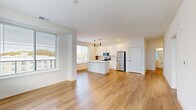 Located at 3939 State Line Rd in Kansas City, MO, this well-appointed 2-bedroom, 2-bathroom residence offers a thoughtfully designed single-floor layout with a clean, contemporary aesthetic throughout. The open-concept living, dining, and kitchen area serves as the heart of the home, bathed in natural light from large windows. The kitchen is a standout feature, boasting white shaker cabinetry, a spacious center island with a built-in sink, stainless steel appliances including a refrigerator, range, and microwave, and sleek pendant lighting overhead. Warm hardwood-style flooring flows throughout the main living areas, lending a cohesive and modern feel. Both bedrooms are carpeted for comfort and feature windows with outdoor views. The generously sized primary bedroom includes a dedicated walk-in closet with built-in shelving. Three total closets provide excellent storage throughout. The two bathrooms mirror each other in style, each featuring a soaking tub with subway-tiled surround, hardwood-style flooring, and clean white finishes. Additional practical spaces include a hallway, pantry, laundry room, utility room, and a welcoming entrance — making this a highly functional and move-in-ready home.