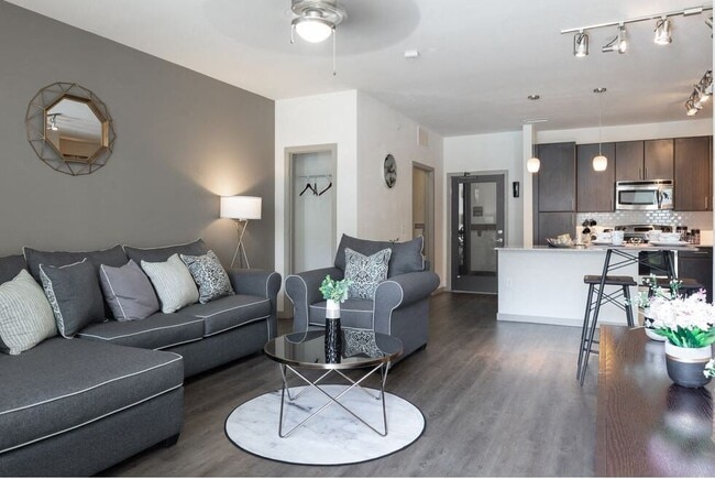 Centro apartments model living room with grey couch and white pillows - Centro