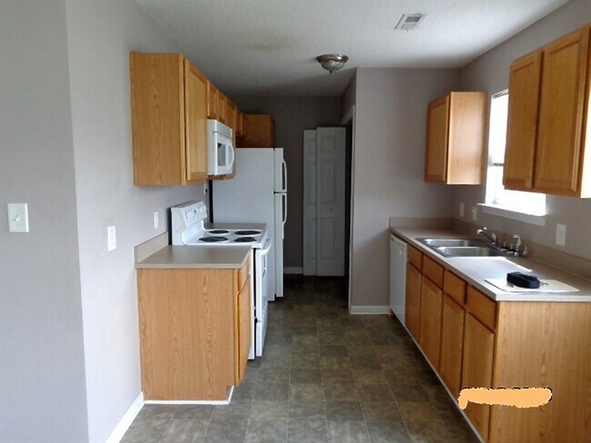 Small kitchen with all the amenities: Dishwasher, Refrigerator/icemaker, Oven, Microwave Range Hood, and W/D connections. - 101 Babs ct