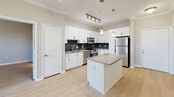 Located at Town Boulevard in Brookhaven, Georgia, this thoughtfully designed 2-bedroom, 2-bathroom residence offers a comfortable and modern living experience on a single floor. The open-concept kitchen and living area serves as the heart of the home, featuring a granite-topped center island, white cabinetry with ample storage, a dark subway tile backsplash, stainless steel appliances, and pendant lighting accented by track lighting. Light wood-style flooring flows seamlessly throughout the main living areas and bedrooms, lending warmth and continuity to the space. A sliding glass door opens to a private balcony with outdoor views, allowing natural light to fill the living room, which also features a ceiling fan. Both bedrooms are well-sized, each with large windows that invite natural light and views of surrounding greenery, and ceiling fans for added comfort. The primary bedroom connects to an en-suite bathroom equipped with granite countertops, white cabinetry, and a walk-in closet with wire shelving. The second bathroom features large-format tile flooring and a glass-enclosed shower. Additional highlights include a dedicated laundry area, a utility room, and four closets providing generous storage throughout the residence.