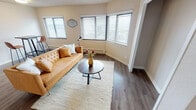 Located in Tacoma, Washington, this single-floor residence at 309 N Tacoma Ave offers a well-organized layout with comfortable living spaces throughout. The living room is a welcoming area defined by wide, multi-panel windows fitted with horizontal blinds that allow generous natural light to fill the room. Dark hardwood-style flooring runs throughout, complemented by warm neutral walls and clean white trim, creating a cohesive and modern aesthetic. A textured ceiling adds architectural character to the space.

The unit features two bedrooms, each with corner or angled bay-style windows that invite additional natural light and provide a sense of openness. The bedrooms share the same consistent flooring and neutral palette found throughout the home.

The kitchen is efficiently designed with white shaker-style cabinetry, light speckled countertops, a stainless steel sink, and stainless steel appliances including a refrigerator and range. The layout maximizes functionality within a compact footprint.

A full bathroom rounds out the interior, featuring a wall-mounted mirror, pedestal sink, and standard fixtures with the same warm hardwood-style flooring tying the space together. Overall, this residence offers a clean, move-in-ready environment with consistent modern finishes in a convenient Tacoma location.