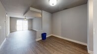 This single-floor residence offers a thoughtfully designed layout with a blend of modern updates and practical living spaces. The open living area is a standout feature, showcasing warm wood-style flooring, a textured ceiling, and a ceiling fan that promotes comfortable airflow. A corner fireplace with a raised hearth serves as a focal point, adding character and warmth to the space. Vertical blinds on a large sliding door allow for natural light while providing privacy.

The kitchen is well-appointed with crisp white cabinetry, light quartz countertops, a subway tile backsplash, a deep double-basin stainless steel sink, and stainless steel appliances including a dishwasher and range. A window above the counter brings in natural light.

A connecting hallway leads to multiple bedrooms, each finished with neutral carpet, soft gray walls, and windows fitted with horizontal blinds. Ceiling fans are present in select rooms. The bathroom area features white cabinetry with brushed nickel hardware and ample countertop space, with access to adjoining rooms via paneled doors.

Throughout the residence, consistent wood-style flooring, neutral gray tones, and clean white trim create a cohesive and move-in-ready aesthetic.