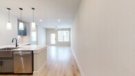 Located at 750 W Grand Pkwy S in Katy, TX, this well-appointed one-bedroom, one-bathroom unit offers a thoughtfully designed layout with modern finishes throughout. Light wood-tone flooring flows through the main living areas, complemented by neutral wall tones that create a bright, clean aesthetic.

The open-concept kitchen and living area serves as the heart of the unit. The kitchen features gray shaker-style cabinetry with matte black hardware, a large white quartz island with an undermount sink and matte black faucet, stainless steel appliances including a French door refrigerator, electric range, and built-in microwave, and elegant pendant lighting overhead.

The bedroom offers plush wall-to-wall carpeting, a ceiling fan, and a window with natural light. A dedicated closet provides built-in open shelving for organized storage.

The bathroom is generously sized with light wood flooring, gray cabinetry with white quartz countertops, a dual undermount sink with matte black fixtures, a large frameless glass walk-in shower with marble-style tile surround, and a wide vanity mirror.

A private balcony with a glass-paneled door extends the living space outdoors, providing outdoor views. The unit combines modern design with functional living in a convenient Katy location.