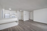 Located at 1225 E Grand Ave in Escondido, CA, this one-bedroom, one-bathroom unit offers a well-organized, single-floor layout designed to maximize every square foot. The open-concept living, dining, and kitchen area forms the heart of the space, where light wood-tone flooring flows seamlessly throughout. Large sliding glass doors in the living room flood the area with natural light and open onto a private balcony, providing an outdoor retreat with views of the surrounding neighborhood. A textured ceiling adds subtle architectural character to the living space.

The kitchen is bright and functional, featuring white cabinetry, a full suite of white appliances including a refrigerator and electric range, an under-cabinet range hood, and a window with vertical blinds that lets in additional natural light. A peninsula counter separates the kitchen from the living and dining area, offering added workspace and a casual dining option.

The bedroom is a quiet, well-lit room with a window and textured ceiling, accompanied by two generously sized closets — one of which provides walk-in style storage with built-in shelving and hanging rods. The full bathroom includes a tub/shower combination, a single-sink vanity with white cabinetry, and a large mirror, all finished in a clean, neutral palette.