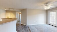 Located at 50 Meadows Drive in Lebanon, TN, this two-bedroom, two-bathroom single-story home offers a well-organized, functional layout designed for comfortable everyday living. The combined kitchen and living area forms the heart of the home, with the kitchen featuring warm wood-toned cabinetry, ample upper and lower cabinet storage, light countertops, and hardwood-style flooring. Track lighting illuminates the kitchen, which opens to the living area via a curved breakfast bar. The spacious living room is finished with plush carpeting, neutral warm-toned walls, a ceiling fan with light fixture, a textured ceiling, and a set of French doors that invite natural light and lead to an outdoor patio area. Both bedrooms are generously proportioned, carpeted for comfort, and finished with the same neutral palette, providing a calm and restful atmosphere. Each bedroom includes closet space. The two bathrooms are practical and well-appointed, each featuring a vanity with wood-accented cabinetry, a large mirror, and a shower-tub combination. Hardwood-style flooring carries through the bathrooms and hallways, creating a cohesive flow throughout the home. Clean white trim and baseboards provide a crisp finish throughout the entire space.