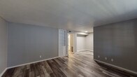 This single-story, 2-bedroom, 2-bathroom residence in Lafayette, Louisiana offers a clean, modern aesthetic with thoughtfully updated finishes throughout. The living area greets you with rich, dark wood-look laminate flooring, neutral gray walls, and a large window that allows natural light to fill the room, creating a welcoming and open atmosphere. A textured ceiling and crisp white baseboards add a classic touch throughout the home.

The kitchen is a standout feature, boasting white shaker-style cabinetry, granite-look countertops, a stainless steel double-basin sink, and a stainless steel range. A window above the counter brings in natural light, and light-toned wood-look flooring complements the bright, clean aesthetic.

Both bedrooms are comfortably sized, each equipped with a ceiling fan with light fixture, a window with blinds for natural light and privacy, and the same wood-look flooring carried throughout the home. Built-in shelving and cabinetry add convenient storage options in the living areas.

The bathrooms are neatly finished with white tile wainscoting, a tub and toilet combination, and updated white vanity cabinetry. A hallway connects the bedrooms and bathrooms efficiently, with light-toned flooring tying the spaces together cohesively.