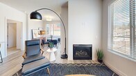 Located at 141 36th St in Los Alamos, NM, this single-story residence offers a thoughtfully designed layout across two bedrooms and two bathrooms. The open-concept kitchen and living area serves as the heart of the home, where light wood cabinetry, granite countertops, stainless steel appliances, and wood-look flooring create a clean, contemporary aesthetic. A large granite-topped island with bar seating adds functionality, while pendant lighting and recessed fixtures provide balanced illumination throughout.

The living room features a built-in fireplace, a ceiling fan, and a large window that brings in natural light and views of the surrounding neighborhood. Both bedrooms are finished with plush carpet, generous windows, and neutral walls that contribute to a calm, restful atmosphere. The primary bedroom includes access to a dedicated closet. The secondary bedroom offers a similarly comfortable layout.

The two bathrooms are well-appointed with wood-toned vanities, granite countertops, and wood-look flooring. One bathroom includes a glass-enclosed shower, while the other features a soaking tub and shower combination. Together, the spaces reflect a cohesive, modern design sensibility suited to everyday living.