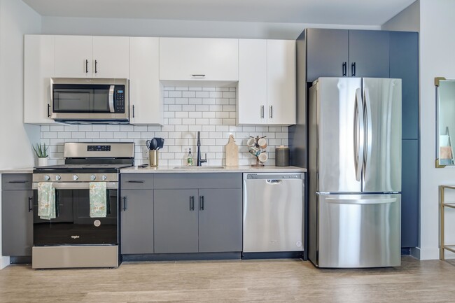 Modern kitchens outfitted with stainless steel appliances and quartz countertops with tile backsplashes. - Modera New Rochelle