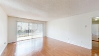 Located at 23939 Ocean Ave in Torrance, CA, this well-appointed 1-bedroom, 1-bathroom unit offers a thoughtfully designed single-level layout. The open-concept living room and kitchen area is anchored by gleaming hardwood floors and a textured ceiling, with large sliding glass doors fitted with vertical blinds that invite abundant natural light and provide outdoor views. The kitchen has been tastefully updated with crisp white cabinetry, granite countertops, a decorative tile backsplash, stainless steel appliances including a range, microwave, and dishwasher, plus track lighting overhead. The spacious bedroom features soft wall-to-wall carpeting, a large window with vertical blinds for natural light, and a mirrored sliding closet door that adds both functionality and a sense of depth to the room. The bathroom is finished with a marble-patterned granite vanity countertop, an undermount sink with brushed nickel fixtures, and a full tub and shower enclosure. A hallway connects the main living areas seamlessly. Throughout, the unit maintains a clean, neutral palette with white walls and consistent trim, creating a bright and inviting atmosphere well-suited for comfortable everyday living.