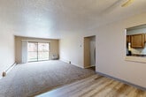 Located at 2746 Fleur Dr in Des Moines, Iowa, this single-floor, 3-bedroom, 2-bathroom residence offers a practical and comfortable layout designed for everyday living. The living room serves as the heart of the home, featuring a combination of plush carpet and light wood-style flooring, a textured ceiling, and a sliding glass door that opens to a private balcony, allowing for natural light and outdoor views. A wall-mounted AC unit and baseboard heating ensure year-round comfort. The kitchen is accessible via a half-wall pass-through, equipped with warm oak cabinetry, dark laminate countertops, a stainless steel double sink, and black appliances. The three bedrooms are carpeted and include closets — the primary bedroom features a spacious closet with sliding doors — while additional bedrooms offer open closets with built-in shelving and windows that bring in natural light. The bathrooms are finished with light wood-style flooring, white vanity cabinetry, a well-lit mirror, and a tub-shower combination. A connecting hallway ties all rooms together efficiently, completing this thoughtfully arranged home.