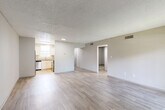 Located at 4581 South Kirkman Road in Orlando, Florida, this 2-bedroom, 1-bathroom single-floor unit offers a practical and well-appointed layout. Light wood-style flooring runs consistently throughout the space, complementing the neutral-toned walls and textured ceilings to create a clean, cohesive aesthetic.

The open-concept living and dining area is bright and spacious, with easy access to the kitchen and a sliding glass door that invites natural light. The kitchen stands out as a key feature, outfitted with white shaker cabinetry, granite-style countertops, a stainless steel refrigerator, dishwasher, microwave, and electric range — all complemented by a window above the sink.

Both bedrooms offer comfortable proportions with wood-style flooring, neutral walls, and natural light from windows with blinds. The primary bedroom is generously sized and includes its own closet access. The full bathroom is neatly finished with a white vanity, granite countertop, framed mirror, and matching hardware.

A hallway connects the main living areas to the bedrooms and bathroom, with four closets throughout providing excellent storage. The utility room houses an in-unit washer and additional shelving. This well-organized unit combines functional design with updated finishes throughout.