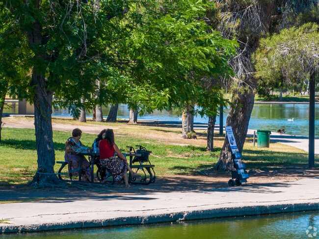 Locals relax by the lake on benches at Cesar Chavez Park in South Phoenix.