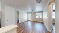 This single-story home offers a well-organized layout across three bedrooms and two bathrooms, finished with consistent wood-look vinyl plank flooring that runs throughout the entire space. The open-concept kitchen and living area forms the heart of the home. The kitchen is outfitted with white shaker-style cabinetry, bright white countertops, stainless steel appliances including a refrigerator, range, microwave, and dishwasher, and a peninsula that provides additional counter space and separates the kitchen from the living area. A window above the sink allows natural light into the workspace.

The living room is spacious and bright, featuring a ceiling fan, a exterior door, and multiple windows fitted with blinds that invite natural light while maintaining privacy. A pet door is also integrated into the exterior wall.

The primary bedroom is generously sized and includes a dedicated walk-in closet with dual hanging rods and shelving. Its en-suite bathroom features a double-sink vanity with white cabinetry, white countertops, and a glass-enclosed shower. The secondary bedrooms each include natural light from windows and sliding or standard closet storage. The overall aesthetic is clean, modern, and neutral throughout.