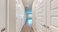 Located at 3030 Ascend Oak St, Unit 209, in Apopka, FL, this single-story residence spans 1,250 square feet and features 3 bedrooms, 2 bathrooms, and a combined kitchen and living area. The open-concept kitchen is outfitted with white shaker-style cabinetry, gray quartz countertops, a subway tile backsplash, stainless steel appliances including a refrigerator, microwave, and range, and a central island with pendant lighting overhead. Wood-look luxury vinyl plank flooring runs throughout the main living areas and bathrooms, contributing to a cohesive, contemporary aesthetic. The living room receives natural light through a glass exterior door. The primary bedroom measures 190 square feet and features carpeted flooring, a ceiling fan, and access to an en-suite bathroom equipped with dual white vanities, gray countertops, a walk-in shower with tile surround, and a tub-shower combo. Secondary bedrooms are carpeted and include ceiling fans and closets with built-in shelving. Neutral beige tones on the walls complement the clean white trim throughout, creating a bright and functional living environment.