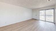 Located at 900 Calla Avenue in Imperial Beach, California, this 2-bedroom, 1-bathroom unit offers a thoughtfully laid-out single-floor design with a bright, clean aesthetic throughout. The open-concept living and dining area flows seamlessly into the kitchen, creating a spacious and functional common area. Light wood-style flooring runs throughout the entire unit, complementing the crisp white walls and textured ceilings to create an airy, cohesive feel. The kitchen is well-appointed with white shaker-style cabinetry, warm butcher block countertops, white subway tile backsplash, open wall shelving, and white appliances including a range and refrigerator. A window above the sink allows natural light to fill the space. The living area features a sliding glass door with vertical blinds, offering access to an outdoor area. Both bedrooms are generously proportioned with light flooring, white walls, textured ceilings, and windows that bring in natural light. The primary bedroom provides a comfortable and spacious retreat. The bathroom features wood-look tile flooring, a sage green vanity with mirror, and a glass-enclosed shower area. Overall, the unit presents a clean, functional, and light-filled living environment.