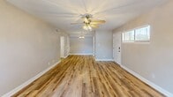 Located at 19 Landmark Dr in Columbia, SC, this one-bedroom, one-bathroom unit offers a thoughtfully arranged single-floor layout designed for comfortable everyday living. Warm-toned wood-look flooring flows consistently throughout, lending a cohesive and modern feel to the entire space.

The spacious living room is a standout feature, bathed in natural light from large sliding glass doors that open to an outdoor patio, providing pleasant outdoor views. A ceiling fan adds both function and style to the room. The open sightlines from the living area into the hallway give the unit an airy, connected feel.

The galley-style kitchen is well-appointed with crisp white shaker cabinetry, dark granite-style countertops, a stainless steel sink with a modern faucet, and a full suite of black stainless steel appliances including a refrigerator, range, and dishwasher. A window above the counter brings in natural light, making the kitchen bright and functional.

The bedroom is a comfortable, well-proportioned retreat featuring a ceiling fan, a natural light-filled window with exterior views, and a mirrored closet that enhances the sense of space. The full bathroom includes a full-size soaking tub with an overhead shower, finished in clean white surrounds. A hallway and dedicated closet complete the layout, providing practical storage solutions throughout.