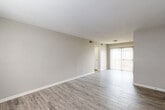 Located at 1 Jeff Nichols Ln in Lexington, NC, this one-bedroom, one-bathroom unit offers a practical and comfortable single-floor layout. The open living room is bright and welcoming, featuring wood-look LVP flooring, neutral gray walls, and a sliding glass door with vertical blinds that fills the space with natural light and provides access to the outdoors. The kitchen is functionally designed with dark espresso cabinetry, light countertops, wood-look flooring, and black appliances including a gas range and dishwasher. A ceiling-mounted light fixture provides ample illumination. The bedroom is generously sized, carpeted for comfort, and equipped with a ceiling fan with light. It features a dedicated closet and easy access to the hallway, with a window allowing in natural light. The full bathroom is clean and well-appointed, showcasing a white vanity with a large mirror and Hollywood-style lighting, a tub-shower combo, and wood-look flooring that ties the space together cohesively. Four closets throughout the unit provide substantial storage. The neutral color palette and consistent finishes create a unified, move-in-ready atmosphere throughout.