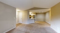 Located at 1300 Beaver Ruin Rd in Norcross, Georgia, this single-floor unit offers a well-designed open-concept layout that promotes a sense of spaciousness throughout. The living area features vaulted ceilings and plush wall-to-wall carpeting, with warm neutral tones creating a welcoming ambiance. A sliding glass door leads directly to a private balcony overlooking lush greenery, filling the living space with abundant natural light.

The kitchen is thoughtfully positioned adjacent to the living area and features an open pass-through breakfast bar with light granite-style countertops, white cabinetry, wood-look vinyl flooring, and a full suite of stainless steel appliances including a refrigerator, range, microwave, and dishwasher. Recessed lighting adds a modern touch to the space.

The bedrooms are generously sized, each with plush carpeting, large windows that frame views of surrounding trees, and ceiling fans for added comfort. The textured ceilings and soft neutral wall colors carry throughout, maintaining a cohesive and calm aesthetic.

The bathroom is clean and functional, featuring a tiled tub-shower combination with white tile surround. The overall design of this unit emphasizes comfort, practicality, and easy livability in a convenient Norcross location.