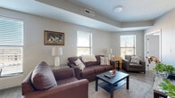 Located at 17 E Lane Ave in Columbus, Ohio, this well-designed 2-bedroom, 2-bathroom residence offers a thoughtful, single-floor layout. The open-concept living, dining, and kitchen area serves as the heart of the home, showcasing hardwood-style flooring and an abundance of natural light from multiple windows. The kitchen is equipped with stainless steel appliances, including a range, microwave, and refrigerator, complemented by gray cabinetry, a subway tile backsplash, and a granite-topped island with seating — ideal for both cooking and casual dining. The living area offers generous space with natural light streaming through large windows. Both bedrooms feature carpeted floors and large windows, with the primary bedroom offering a spacious walk-in closet fitted with open wire shelving and hanging rods for ample storage. The two bathrooms are finished with light-toned luxury vinyl plank flooring and clean, neutral palettes. Additional highlights include a dedicated laundry area and a utility room, enhancing everyday convenience. The overall design balances modern finishes with functional living spaces, making this residence a comfortable and practical home in Columbus.