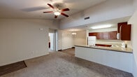Located at 102 Fowler Avenue in Clovis, CA, this single-floor, one-bedroom, one-bathroom unit offers a thoughtfully designed layout that maximizes every square foot of its compact footprint. The open-concept living and dining area flows seamlessly into the kitchen, creating a connected, airy feel enhanced by vaulted ceiling sections and ceiling fans overhead. The kitchen is well-equipped with rich, warm-toned cabinetry, light granite-style countertops, a peninsula breakfast bar with a built-in sink, and white appliances including a refrigerator, electric range, and microwave. Light hardwood-style flooring in the kitchen transitions to plush carpet in the living and dining spaces. The bedroom is a comfortable, carpeted retreat featuring a ceiling fan, a large window with vertical blinds that invite natural light, and access to multiple closets offering generous storage. The combined bathroom and laundry room adds everyday convenience. A patio provides a private outdoor area, while a utility room rounds out the practical amenities. Neutral tones throughout create a clean, versatile canvas ready for personalization.