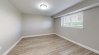 Located at 900 Mickley Rd in Whitehall, PA, this efficiently designed single-floor unit offers a well-planned layout comprising a living room, kitchen, bathroom, closet, and two hallways. Throughout the space, light-toned luxury vinyl plank flooring provides a clean, cohesive look that enhances the sense of openness.

The living room is a bright, open area illuminated by a flush-mount ceiling light and a window fitted with white horizontal blinds that allow natural light to filter in. Neutral gray walls and crisp white baseboards give the room a modern, move-in-ready feel.

The kitchen is outfitted with white shaker-style cabinetry, granite countertops, and stainless steel appliances including a refrigerator, microwave, and range. A window above the counter brings in natural light, making the galley-style space feel airy and functional.

The bathroom features large-format gray tile flooring, a soaking tub with tiled surround, and gray vanity cabinetry — creating a clean, contemporary aesthetic. A wall-mounted mini-split HVAC unit ensures climate control throughout the space. Hallways connect the rooms efficiently, with a dedicated closet providing additional storage. The overall ambiance is fresh, modern, and well-maintained.