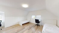 Located at 1770 La Loma Ave, Unit 34AB in the heart of Berkeley, CA, this single-bedroom space offers a clean, minimalist design that maximizes both functionality and comfort. The room features light-toned hardwood flooring throughout, which enhances the sense of openness and warmth. A distinctive sloped ceiling lends the space a charming, attic-like architectural character, adding visual interest while maintaining a comfortable feel. The crisp white walls and ceiling reflect natural light effectively, contributing to a bright and airy ambiance. Two windows allow natural light to filter into the room, offering views of the surrounding Berkeley neighborhood and greenery. A standout feature is the full-width mirrored closet, which spans nearly an entire wall and serves both as practical storage and a design element that amplifies the sense of space. The room is well-suited for use as a bedroom and study area, with ample space for a bed, desk, and seating. Flush ceiling lighting provides consistent illumination throughout. Overall, this space presents a thoughtfully laid-out, light-filled room with architectural character, ideal for those seeking a functional and stylish living environment in Berkeley.