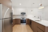 This 1,040 square foot apartment in Collingswood, NJ, offers a harmonious blend of modern design and practical living. The open-concept layout maximizes the use of space, creating a seamless flow between the living areas. The gourmet kitchen is a standout feature, boasting a U-shaped design with sleek cabinetry in a two-tone finish, stainless steel appliances, and a generous island with pendant lighting.

The spacious bedroom, measuring 180 square feet, provides ample room for rest and relaxation. It features a large window that allows natural light to flood the space, enhancing the airy feel. The apartment boasts two bathrooms, both finished to a high standard. One bathroom showcases elegant marble-like flooring and a stylish vanity, while the other offers a modern shower/tub combination with designer tiling.

Throughout the apartment, light wood flooring adds warmth and continuity. Recessed lighting and crisp white walls contribute to the bright, contemporary ambiance. The unit also includes two closets, providing excellent storage solutions. The attention to detail in the finishes and the thoughtful layout make this apartment a perfect example of modern urban living.