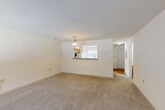 Located at 10751 Venetia Mill Circle in Silver Spring, Maryland, this two-story home offers a functional and well-organized layout across two floors. The main level welcomes you through a dedicated entrance that opens into a spacious combined living and dining area, finished with neutral wall-to-wall carpeting and a decorative pendant light fixture. A pass-through window connects the living space to the kitchen, enhancing the open feel of the main floor. The kitchen features warm honey-toned wood cabinetry, hardwood-style flooring, ample counter space, and white appliances including a dishwasher, electric range, and refrigerator. A full bathroom is also conveniently located on the main level. Upstairs, a carpeted hallway leads to three well-proportioned bedrooms, each offering closet space and natural light from windows. The generously sized primary bedroom includes an en-suite bathroom. The additional bedrooms share access to a full bath, each bathroom featuring clean white tile, a tub-shower combination, and wood-tone vanity cabinetry. With four closets throughout the home, storage is plentiful. The clean, neutral palette and practical layout make this Silver Spring residence a move-in ready home.