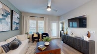 Located at Bay Island Lane in Kissimmee, Florida, this thoughtfully designed 1-bedroom, 2-bathroom residence offers a cohesive and modern living experience across a single floor. The open-concept kitchen is a standout feature, boasting crisp white shaker cabinetry extending to the ceiling, a white quartz countertop island with pendant lighting, full-height subway tile backsplash, and a complete suite of stainless steel appliances including a gas range, built-in microwave, dishwasher, and French door refrigerator. Warm wood-look flooring flows throughout, connecting the kitchen seamlessly to the living room, which is highlighted by a sage green accent wall, large windows with plantation shutters, a ceiling fan, and generous natural light. The primary bedroom continues the sage green palette and features a window with outdoor views, a ceiling fan, and access to its own dedicated bathroom. Both bathrooms are finished with gray vanity cabinetry, framed mirrors, and clean tile work. A dedicated closet provides additional storage. The overall ambiance is contemporary and welcoming, with neutral tones, quality finishes, and a functional layout that makes excellent use of the available space.