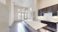 This contemporary 930 square foot apartment in Central Square at Frisco offers a harmonious blend of style and functionality. The space boasts two bedrooms, including a spacious primary bedroom of 160 square feet, and two full bathrooms. The modern kitchen is a highlight, featuring dark wood cabinetry contrasting beautifully with light countertops and stainless steel appliances. A kitchen island provides additional prep space and casual dining options.

Large windows in the bedrooms allow for abundant natural light, creating a bright and airy atmosphere. The bathrooms are finished with neutral-toned tiles and modern fixtures, offering both style and practicality. Ample storage is available throughout, with walk-in closets and additional shelving units.

The apartment's open floor plan and use of light colors contribute to a sense of spaciousness. Carpet in the bedrooms adds comfort, while the kitchen and common areas feature durable, attractive flooring. The overall design aesthetic is clean and minimalist, perfect for those who appreciate modern living spaces.