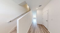 Located at 3119 Sleepy River Avenue in Ruskin, FL, this two-story home offers a well-organized layout spread across two floors. The main level features an open-concept living, dining, and kitchen area finished with light wood-look flooring throughout. The kitchen is equipped with white shaker-style cabinetry, granite-look countertops, stainless steel appliances, and a sink with a window view. The living area receives ample natural light through large windows and a sliding glass door that opens directly to one of two outdoor patio spaces, offering views of the surrounding greenery. An attached garage and a convenient hallway complete the ground floor.

Upstairs, the more expansive upper level houses all three bedrooms, three closets, two full bathrooms, and a dedicated laundry room. The primary bedroom is generously sized, accompanied by a walk-in closet fitted with wire shelving. The additional bedrooms are carpeted and bright, each with closet access. The bathrooms feature white vanity cabinetry with granite-look countertops and a tub-shower combination. The upstairs laundry room includes wire shelving, washer and dryer hookups, and dedicated electrical connections for added convenience. The home's exterior features modern board-and-batten siding with a well-maintained front lawn.