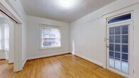 This well-appointed one-bedroom, one-bathroom residence showcases classic architectural character throughout its thoughtfully laid-out single floor. Warm hardwood flooring flows consistently through the living room, hallway, and bedroom, lending a sense of continuity and timeless charm. The living room is a standout space, highlighted by a distinctive bay window with multiple panes that invite natural light and offer pleasant outward views. A freestanding stove unit anchors the bay corner, adding a nostalgic touch to the room's character. Decorative door and wall moldings further reinforce the space's classic aesthetic. The bedroom is generously proportioned, featuring a large paneled double closet, a window overlooking neighboring brickwork, and a secondary glass-paneled door that introduces additional light. The kitchen is functional and well-equipped, featuring warm wood cabinetry, light countertops, a gas range, and a window that brightens the space. The bathroom retains a charming vintage character with a clawfoot soaking tub fitted with an overhead shower fixture, a wall-mounted sink, and clean white finishes. A connecting hallway ties all rooms together efficiently, completing this cohesive and character-rich residence.