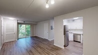 Located at 15 Fox Hall in Newark, Delaware, this single-floor 2-bedroom, 2-bathroom home offers a well-organized layout with a variety of functional spaces including a kitchen, combined dining and living room, hallway, patio, utility room, and three closets. The open living and dining area is finished with durable hardwood-style flooring and neutral gray-toned walls, creating a clean and inviting atmosphere. Sliding glass doors lead to a private patio that overlooks lush, wooded surroundings, bringing natural light and greenery into the main living space. The kitchen features white shaker-style cabinetry, a subway tile backsplash, light countertops, and a full suite of stainless steel appliances including a refrigerator, dishwasher, and range. The two bathrooms differ in style — one is elegantly appointed with marble-look tile walls accented by a blue subway tile border and matching floor tile, while the second features a classic white tub-shower surround. Both bedrooms are carpeted and offer a quiet, comfortable feel, with windows that allow natural light. Closet storage is well-distributed throughout the home, adding to its practical appeal.