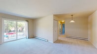 Located at 630 Spruce St in Royersford, PA, this two-bedroom, one-bathroom residence offers a practical and well-organized single-floor layout. The living room is a generously sized space featuring neutral-toned carpet, baseboard heating, a wall-mounted air conditioning unit, and a sliding glass door that fills the room with natural light and provides direct access to an outdoor area with views of the surrounding neighborhood. The kitchen is efficiently designed in a U-shaped configuration, outfitted with gray cabinetry, light countertops, a window above the sink, and includes a refrigerator and electric range. The primary bedroom offers ample space with soft carpeting, multiple windows for natural light, baseboard heating, and a wall A/C unit. It also features generous closet storage with two sets of louvered bi-fold closet doors. The second bedroom is a comfortable, well-proportioned room with carpeting, a window, and baseboard heating. The full bathroom is clean and functional, equipped with a full-size soaking tub and shower combination with crisp white surroundings. Throughout the home, warm neutral tones and carpeted floors create a cohesive and comfortable living environment.