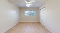 Located at 3545 30th Ave N in Saint Petersburg, FL, this single-floor, one-bedroom, one-bathroom unit offers a compact and efficient layout ideal for comfortable everyday living. Light-toned ceramic tile flooring runs consistently throughout the space, contributing to a clean and cohesive aesthetic. Textured ceilings are present in the main living areas, adding a classic Florida residential character.

The open living area is bright and simply appointed, with neutral cream-colored walls and a wall-mounted ventilation unit. A partial dividing wall separates the living space from the galley-style kitchen, which features white cabinetry, a white refrigerator, a range, a single-basin sink, and a patterned tile backsplash — all arranged in a narrow but functional corridor layout.

The bedroom is a comfortable size, equipped with a ceiling fan with light fixture, a closet with panel doors, and a window that allows natural light and views of the surrounding greenery. The bathroom includes a full tub and shower combination lined with white square tiles, a window for natural ventilation, and a clean, utilitarian finish.

Overall, this unit offers a straightforward, well-lit living environment with consistent finishes throughout, situated in a residential neighborhood of Saint Petersburg.
