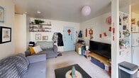 Located at 323 Packard St in Ann Arbor, Michigan, this one-bedroom, two-bathroom residence offers a practical and well-organized single-floor layout. The living room serves as the heart of the home, featuring carpet flooring, a sliding glass door that brings in natural light and provides access to the outdoors, and a built-in shelving unit along one wall. The space flows naturally into a dedicated dining area adjacent to the living room. The bedroom is generously sized, accommodating a full sleeping area with multiple windows on two walls that flood the room with natural light. A wall of built-in closet storage spans the length of the room, offering ample organization. The kitchen is efficiently arranged in an L-shaped layout, equipped with light wood cabinetry, a full suite of appliances including a refrigerator and electric range, and tile flooring. Two bathrooms serve the unit: one features a shower-tub combination with tile surround, while the other includes a double-sink vanity with wood cabinetry and a mirror. A hallway connects the main living spaces, completing the thoughtful flow of this compact yet functional Ann Arbor residence.