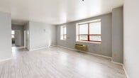 This two-bedroom, two-bathroom residence at 60 Paterson Street in New Brunswick, NJ offers a thoughtfully designed single-floor layout with a clean, modern aesthetic. Light gray walls and wood-look tile flooring flow through the main living areas, creating a bright and cohesive feel throughout the space.

The kitchen is a standout feature, showcasing rich dark cherry cabinetry extending to the ceiling for ample storage, granite countertops with a stone tile backsplash, a stainless steel sink, and a full suite of stainless steel appliances including a range, microwave, and dishwasher.

The spacious primary bedroom features plush carpeting and natural light from a dedicated window, while the second bedroom offers a similar comfortable layout, also with carpet flooring and a window with exterior views. A dedicated walk-in closet with wire shelving provides generous storage.

The bathrooms are well-appointed; one features floor-to-ceiling linear tile work, a soaking tub, a dark-vanity with granite countertop, and coordinating tile flooring. The second bathroom includes a dark granite vanity and tile flooring. An in-unit laundry room with a full-size washer and dryer adds everyday convenience. Two hallways connect the layout efficiently, rounding out this well-equipped New Brunswick residence.