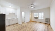 Located in the Koreatown neighborhood of Los Angeles, this single-floor unit at 861 Fedora St offers a clean, modern design with a bright and airy atmosphere throughout. Light-toned hardwood flooring runs seamlessly across the entire space, creating a warm and cohesive aesthetic.

The open main living area is finished with crisp white walls and crown molding, and is equipped with a ceiling fan for added comfort. A wall-mounted air conditioning unit and large multi-pane windows allow for ample natural light and ventilation, enhancing the sense of openness in the room.

The kitchen is efficiently designed and outfitted with white shaker-style cabinetry featuring brushed nickel hardware, white quartz countertops, and a full suite of stainless steel appliances, including a full-size refrigerator, an electric range with overhead ventilation hood, and a sink. The layout maximizes counter and storage space within a compact footprint.

The bathroom is neatly finished in a minimalist style, featuring a white vanity with an integrated sink, a mirrored medicine cabinet, and light wood flooring that continues from the main living area. The space is kept simple and functional with clean white walls and fixtures.

Overall, the unit presents a well-maintained, move-in-ready interior with consistent finishes and practical amenities throughout.