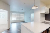 This well-designed 2-bedroom, 3-bathroom residence is laid out on a single floor, offering an efficient and comfortable living environment. The open-concept living and kitchen area forms the heart of the home, featuring rich dark wood-style flooring, crisp white walls, and a large window that fills the space with natural light. A pendant light fixture hangs above the kitchen island, which features a clean white quartz-style countertop. The kitchen is equipped with dark wood cabinetry, white upper cabinets, and full-size stainless steel appliances including a refrigerator and dishwasher.

The primary bedroom is a well-proportioned retreat with wood-style flooring and generous window coverage that brings in ample natural light. The second bedroom features soft carpeting and a bright window with outdoor views. Both rooms connect seamlessly to the shared spaces through clean white-trimmed doorways. A dedicated closet provides additional storage.

The three bathrooms are finished consistently with warm wood-toned vanity cabinetry, white countertops, large mirrors, and light tile flooring. Chrome fixtures and towel bars add a polished, modern touch throughout. The overall aesthetic is clean, contemporary, and move-in ready, with a neutral color palette that offers a versatile canvas for personalization.