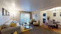 Located at 4125 S 430 E in Salt Lake City, Utah, this single-floor residence offers a thoughtfully designed layout that balances comfort and functionality. The living room is generously sized, featuring plush carpeting, a large sliding glass door with vertical blinds that floods the space with natural light, and seamless access to adjoining areas. A dedicated dining area off the kitchen features warm hardwood-style flooring and an elegant chandelier overhead, creating an inviting setting for meals. The kitchen is equipped with dark espresso cabinetry, dark countertops, hardwood-style flooring, and stainless steel appliances, including a refrigerator and dishwasher, complemented by a window that brings in additional natural light. Both bedrooms are carpeted and well-proportioned, each offering walk-in closet space for ample storage. The two bathrooms are distinct in style: one features a pedestal sink and a tub-shower combination with hardwood-style flooring, while the other offers a dark vanity with granite-style countertops and a well-lit mirror. Throughout the residence, neutral wall tones and consistent flooring materials create a cohesive and calm ambiance, making this a practical and comfortable living space in a convenient Salt Lake City location.