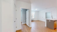 Located at 1001 W Elizabeth Ave in Linden, NJ, this 2-bedroom, 2-bathroom residence is thoughtfully designed to maximize functionality and comfort across a single floor. Light wood-style flooring runs throughout the entire space, lending a warm, cohesive feel to every room.

The open-concept living, dining, and kitchen area serves as the heart of the home. The kitchen is outfitted with stainless steel appliances — including a refrigerator, electric range, and built-in microwave — complemented by warm-toned cabinetry, a white subway tile backsplash, and a large center island with a stone-look countertop and undermount sink, ideal for both meal prep and casual dining.

Both bedrooms feature soft gray accent walls, large windows with blinds that invite natural light and outdoor views of the surrounding neighborhood, and individual wall-mounted HVAC units for personalized climate control. The primary bedroom offers a comfortable footprint with ample space.

The two bathrooms are finished with light gray shaker-style vanities, white quartz countertops, large mirrors, and wood-style flooring. The unit also includes in-unit laundry, four closets for generous storage, and a hallway that connects all spaces efficiently. Clean white walls and modern finishes create a bright, contemporary ambiance throughout.