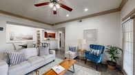Located at 2727 Elmside Dr in Houston, TX, this well-appointed single-floor residence offers 2 bedrooms and 3 bathrooms across a thoughtfully designed layout. The open-concept kitchen is a standout feature, boasting rich warm-toned cabinetry, granite countertops, stainless steel appliances including a range, microwave, and refrigerator, and a breakfast bar with seating. The kitchen flows seamlessly into a hallway that connects the main living areas. The living room is bright and inviting, featuring crown molding, recessed lighting, a ceiling fan, and windows with natural light that illuminate the hardwood-style flooring throughout. Built-in shelving adds functional character to the space. Both bedrooms are generously sized, each with ceiling fans, large windows with blinds, and hardwood-style floors. The primary bedroom includes an en-suite bathroom with a vanity and mirror, providing a private and comfortable retreat. The secondary bedroom also features ample natural light and space for a dedicated work area. Two closets provide excellent storage solutions. The three bathrooms are cleanly finished with neutral tones. Crown molding and consistent flooring tie the entire home together, creating a cohesive and polished aesthetic throughout.