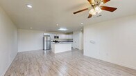 Located at 2247 Stillwater Dr in Beaumont, Texas, this single-story, 3-bedroom, 2-bathroom home offers a clean, modern aesthetic throughout its thoughtfully designed floor plan. Light-toned wood-look tile flooring runs through the main living areas, kitchen, bathrooms, and laundry room, lending a cohesive and contemporary feel across the home.

The open-concept kitchen is a standout feature, equipped with stainless steel appliances, a gas range, a center island with a sink and grey quartz-style countertops, and abundant white shaker cabinetry providing generous storage. The adjoining living room is bright and airy, benefiting from natural light through large windows and a ceiling fan overhead.

The three bedrooms are carpeted for comfort, each featuring ceiling fans and windows that bring in natural light. The spacious primary bedroom includes its own closet. The two bathrooms are finished with grey vanity cabinetry, white countertops, and the same wood-look tile flooring, delivering a clean and modern look. One bathroom features a private toilet area.

A dedicated laundry room accommodates a full-size washer and dryer side by side, with upper cabinetry for additional storage. Three closets throughout the home provide practical storage solutions. The overall ambiance is light, neutral, and move-in ready.