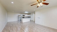 Located at 2247 Stillwater Dr in Beaumont, Texas, this single-story, 3-bedroom, 2-bathroom home offers a clean, modern aesthetic throughout its thoughtfully designed floor plan. Light-toned wood-look tile flooring runs through the main living areas, kitchen, bathrooms, and laundry room, lending a cohesive and contemporary feel across the home.

The open-concept kitchen is a standout feature, equipped with stainless steel appliances, a gas range, a center island with a sink and grey quartz-style countertops, and abundant white shaker cabinetry providing generous storage. The adjoining living room is bright and airy, benefiting from natural light through large windows and a ceiling fan overhead.

The three bedrooms are carpeted for comfort, each featuring ceiling fans and windows that bring in natural light. The spacious primary bedroom includes its own closet. The two bathrooms are finished with grey vanity cabinetry, white countertops, and the same wood-look tile flooring, delivering a clean and modern look. One bathroom features a private toilet area.

A dedicated laundry room accommodates a full-size washer and dryer side by side, with upper cabinetry for additional storage. Three closets throughout the home provide practical storage solutions. The overall ambiance is light, neutral, and move-in ready.