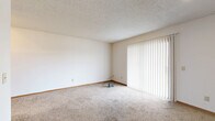 Located at 1985 N Amidon Ave in Wichita, Kansas, this single-floor, 2-bedroom, 3-bathroom residence offers a practical and comfortable layout. The open-concept living, dining, and kitchen area serves as the heart of the home, where a peninsula counter with a built-in sink connects the kitchen to the living space. The kitchen is outfitted with warm oak cabinetry, granite-style countertops, and includes a refrigerator, electric range, and microwave. The living area features plush carpeting, a textured ceiling, and a large sliding glass door with vertical blinds that lets in generous natural light. The spacious primary bedroom includes a ceiling fan, a window, and carpet flooring. The second bedroom also features carpeting and direct closet access. Throughout the unit, warm wood-toned door frames and trim provide consistent detailing. Three bathrooms offer convenience, with finishes including wood-look vinyl flooring, granite-style vanity countertops, and a full tub/shower combo. A dedicated laundry area with washer and dryer hookups adds everyday practicality. Four closets distributed across the floor plan ensure abundant storage. A connecting hallway ties the private and shared spaces together efficiently.